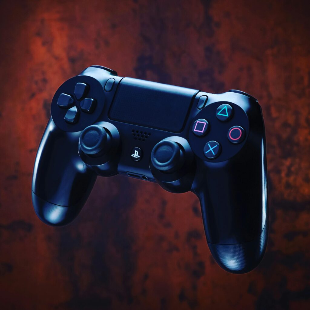 Modern PlayStation controller with glowing buttons on a dark textured backdrop.
