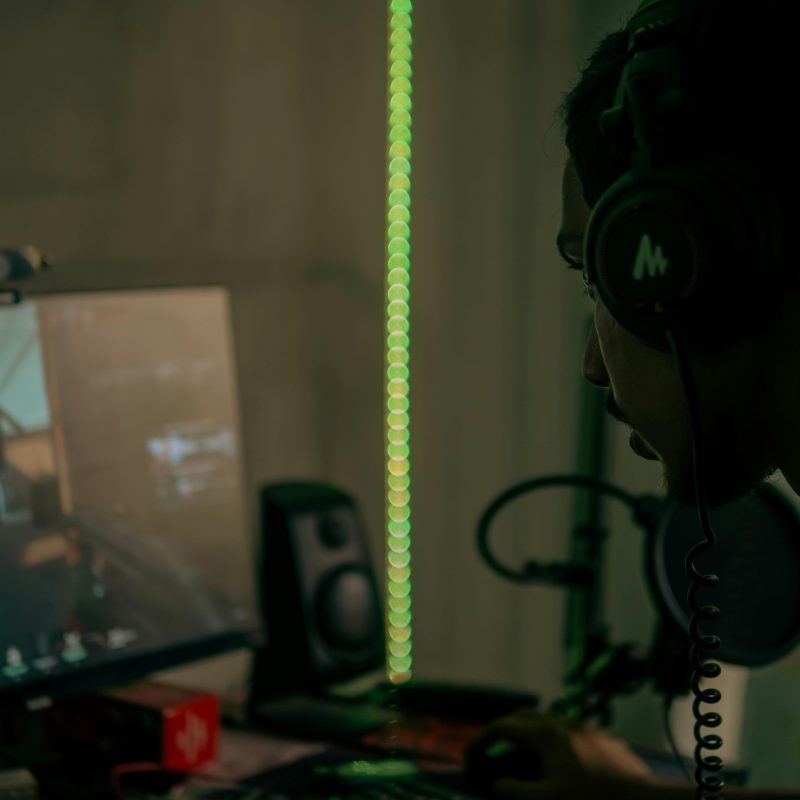 Focused gamer with headset playing a video game on a desktop computer indoors.